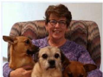 photo of Mrs. McCurdy with 3 dogs in her lap