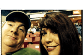 selfie of Mrs. Meyer and her husband seated at a sports game